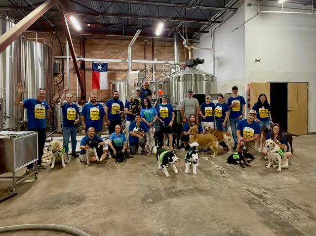 Group gathered in the brewhouse with service dogs